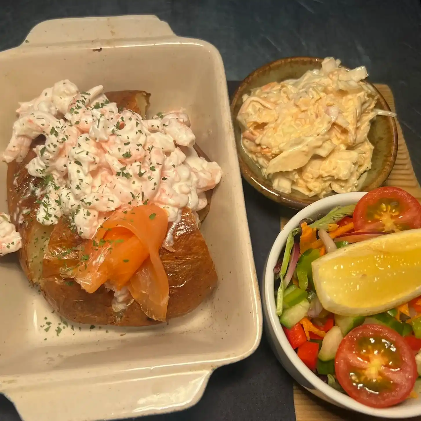 A plate of food and a bowl of salad on a table.