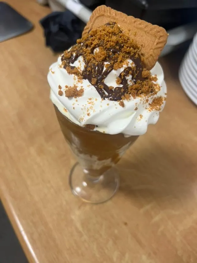 An ice cream sundae with a biscuit on top.