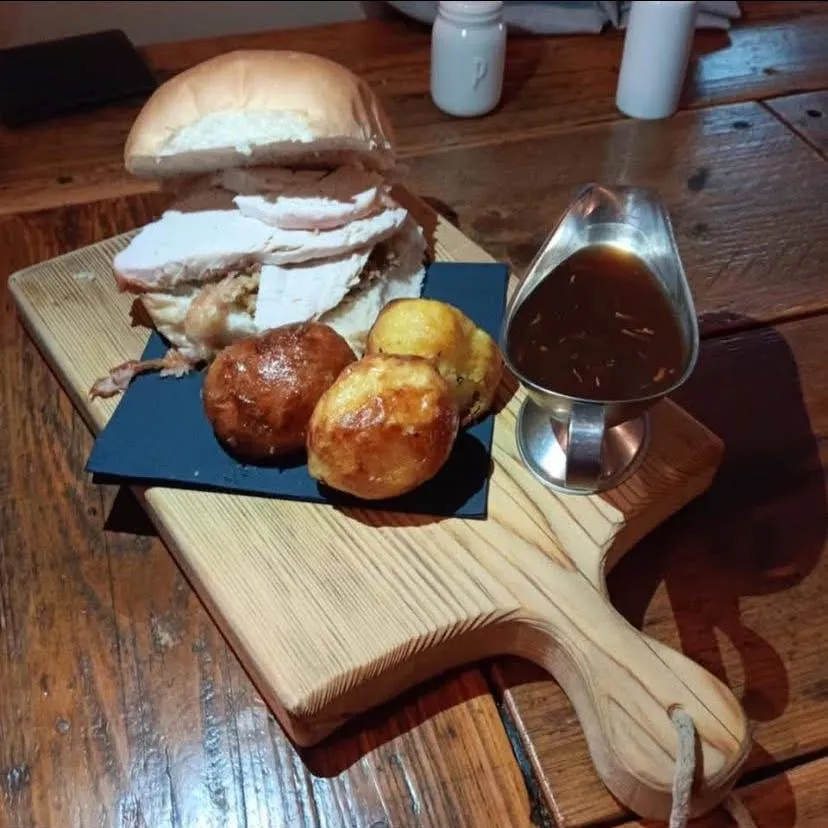 A burger with jacket potatoes and gravy.