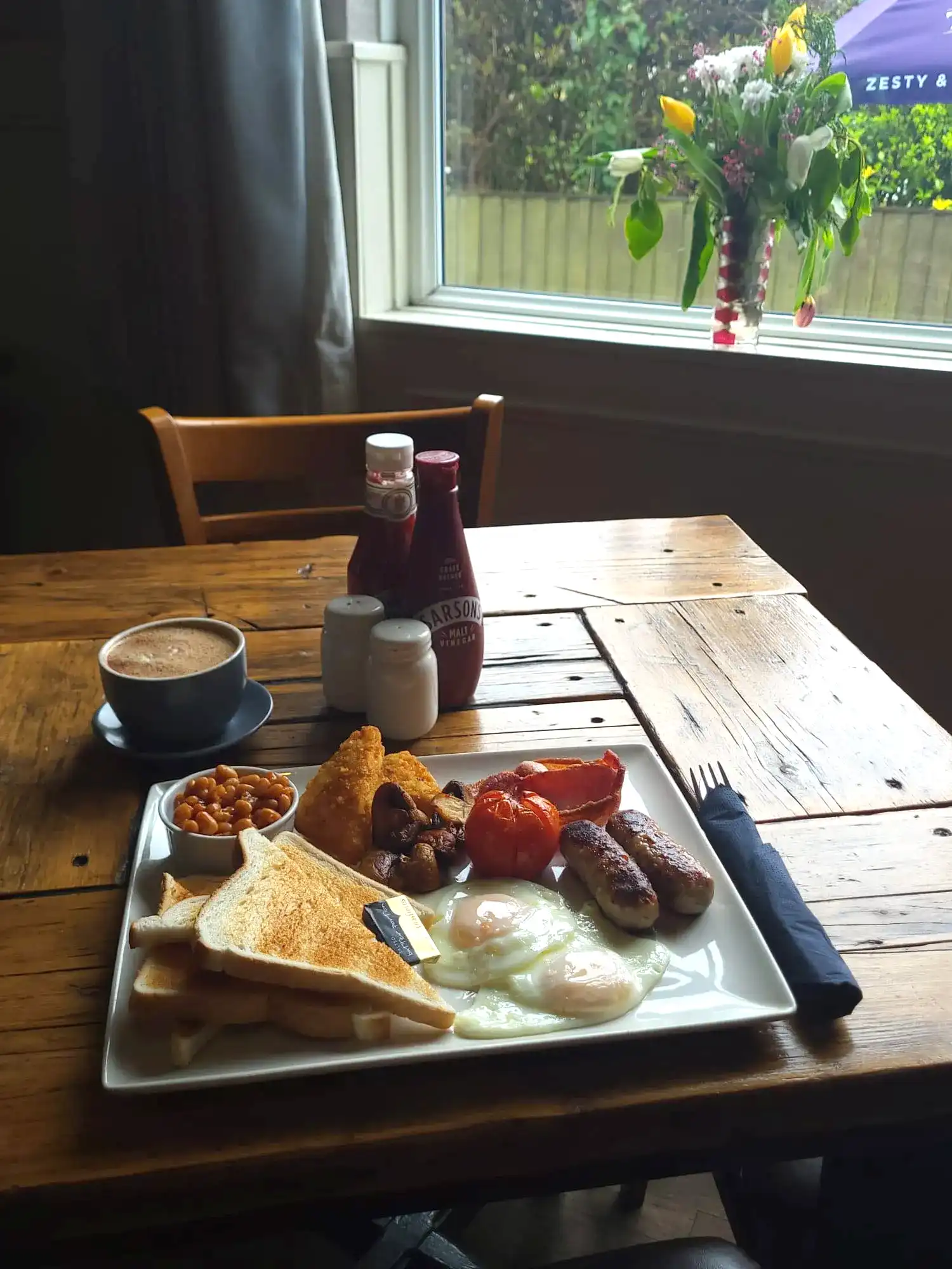 A full english breakfast with a cup of coffee.
