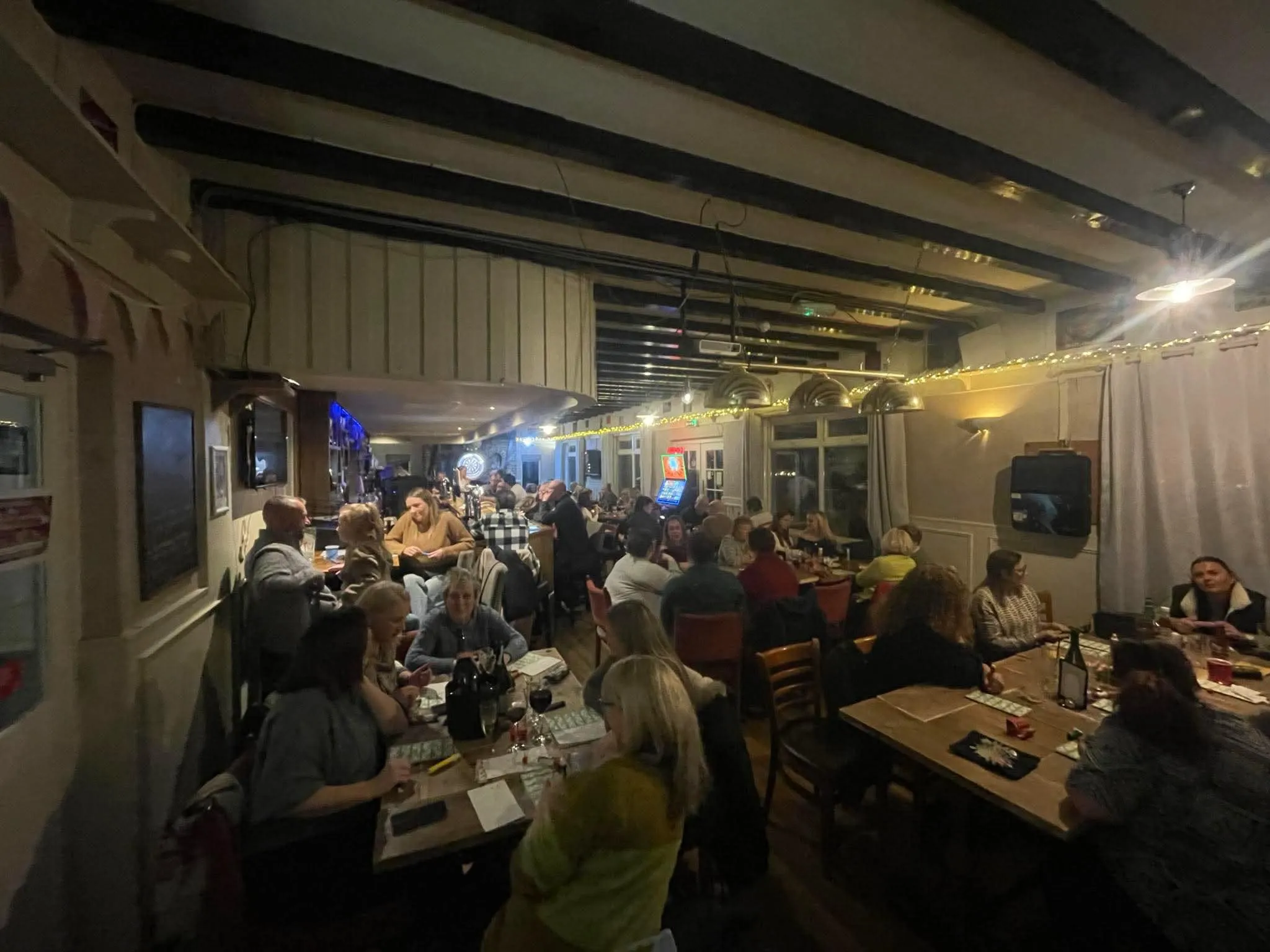A group of people sitting at tables in a restaurant.