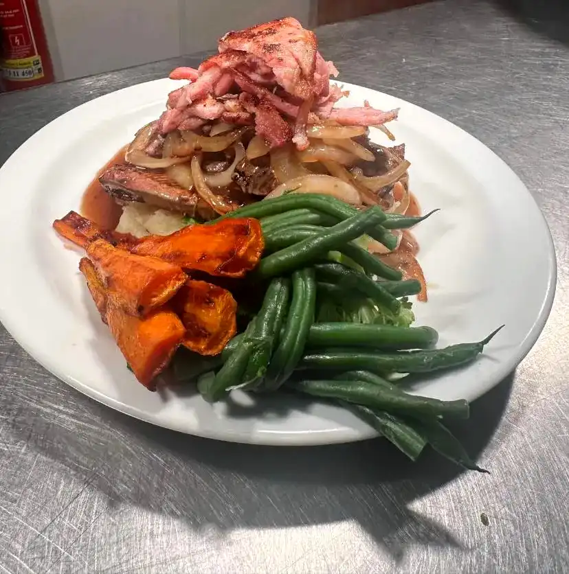 A white plate topped with meat and vegetables.