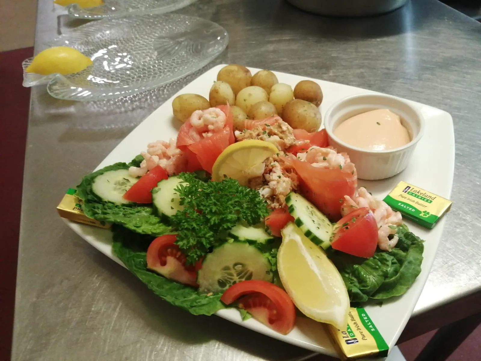 A white plate topped with a salad and potatoes.