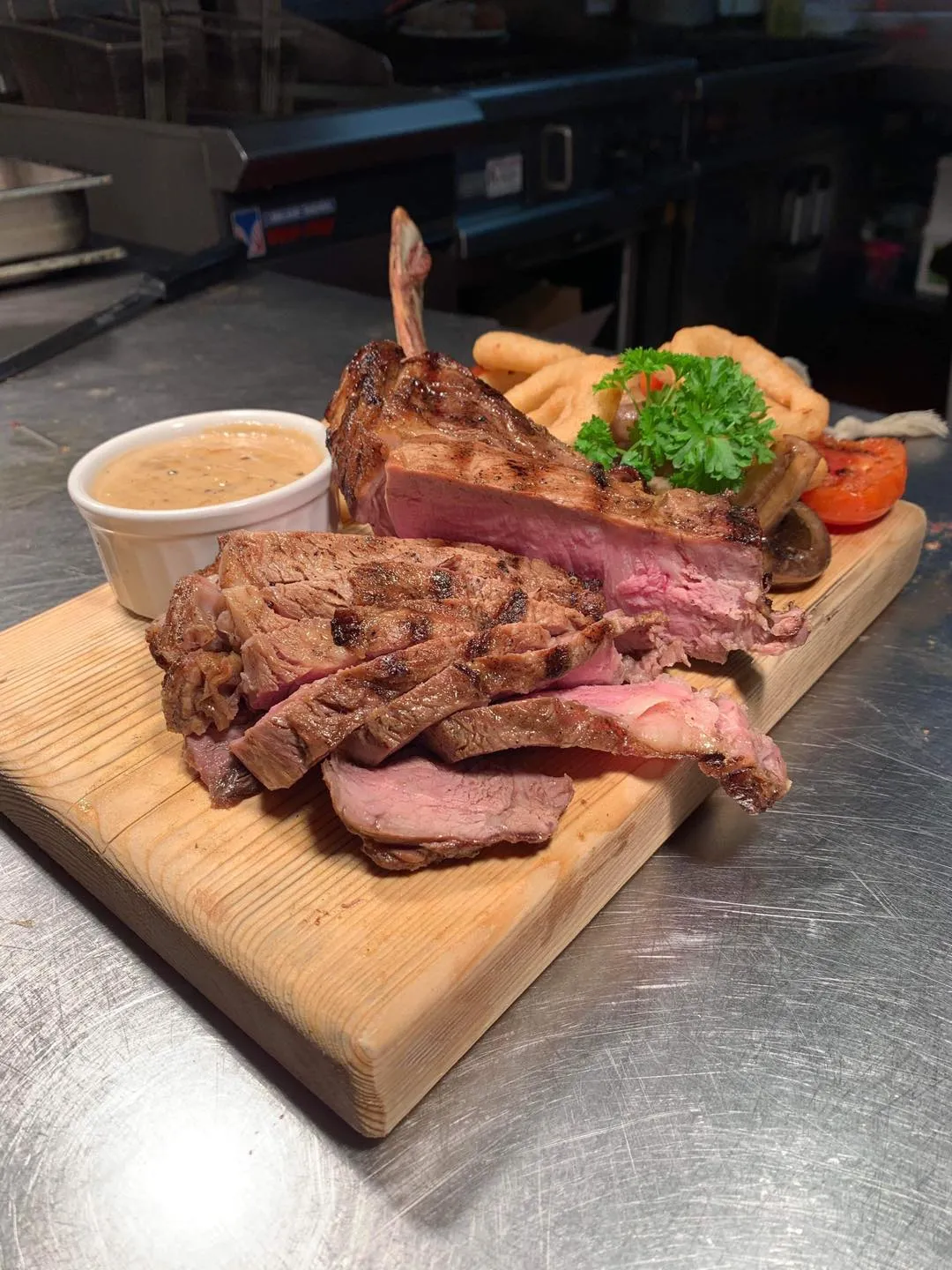 A wooden cutting board topped with steak and chips.