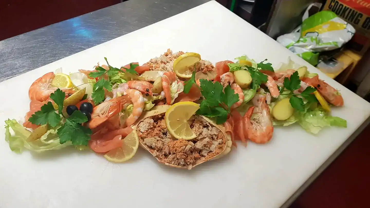 A white cutting board topped with prawns.
