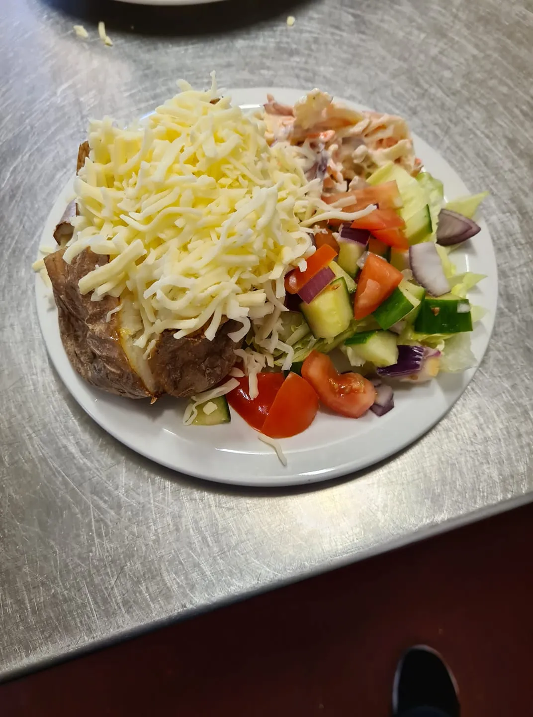A jacket potato with cheese and a side salad.
